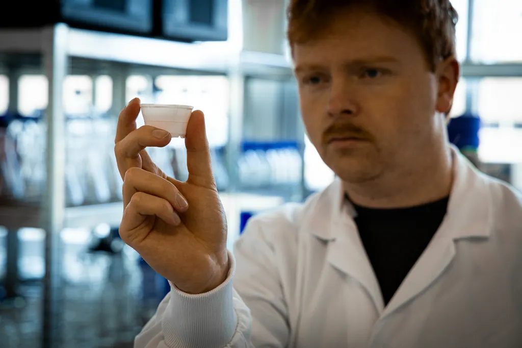 Een teamlid bekijkt een cupje van cellulose in het lab